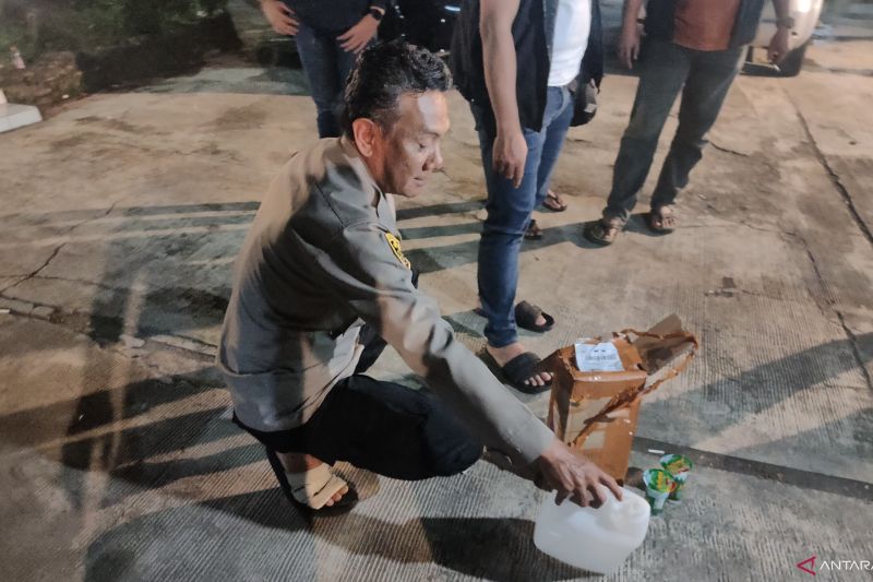 Kapolsek Mande Cianjur AKP Dadeng, saat mengamankan barang bukti alkohol murni yang dipakai pesta miras oplosan oleh para korban di Desa Kademangan.(ANTARA/Ahmad Firkri).