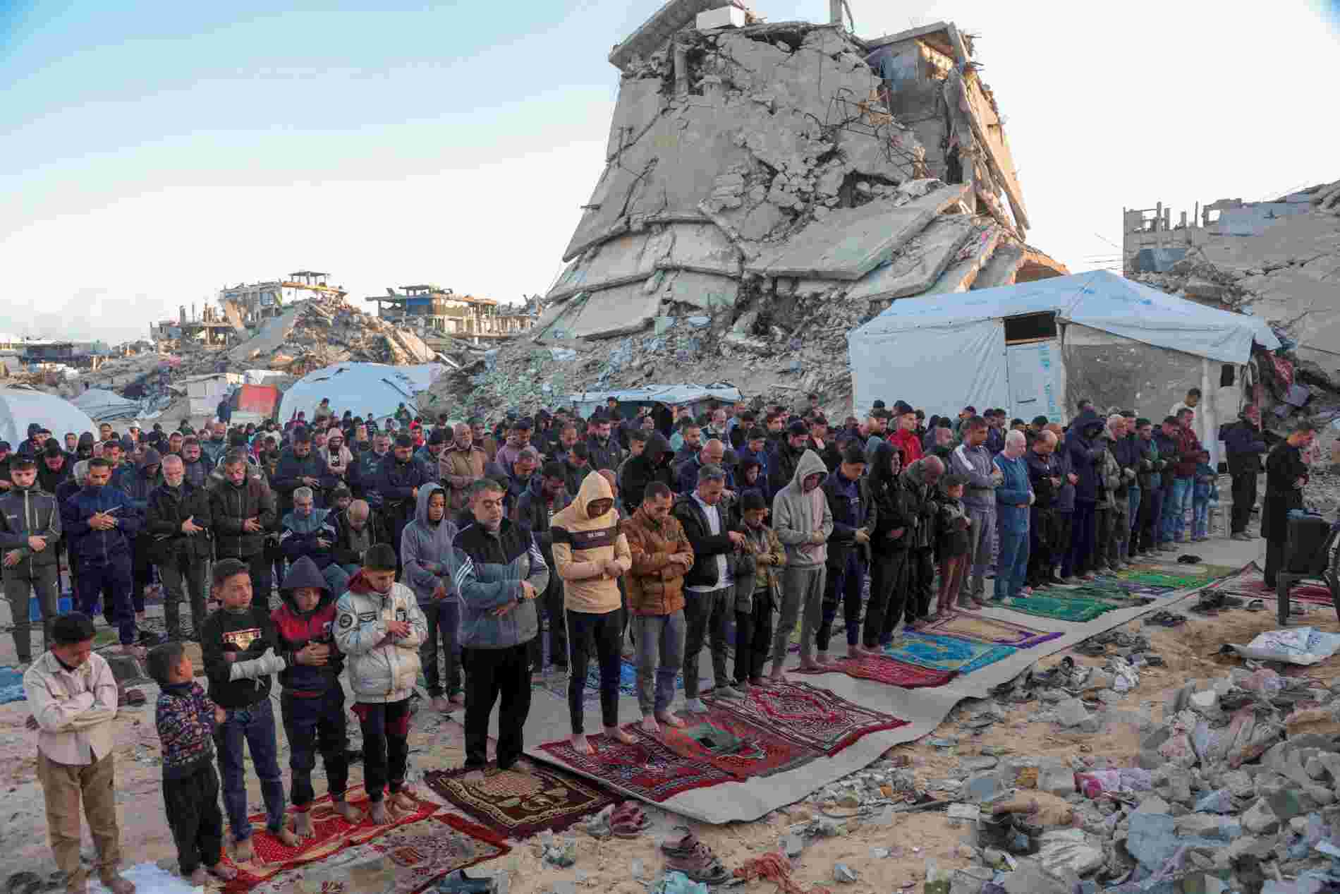 Umat Islam menunaikan salat Idulfitri 1446 Hijriah di ruang terbuka dekat reruntuhan gedung di Jalur Gaza, Palestina, Minggu (30/3/2025). Foto: Istimewa