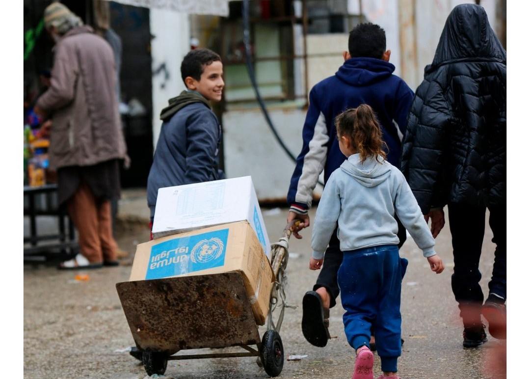 Anak-anak di Jalur Gaza membawa bantuan makanan yang disalurkan dari UNRWA. Foto: UNRWA